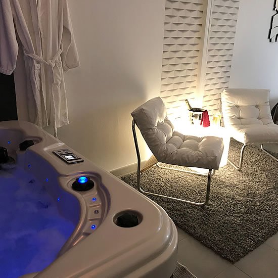 Spa privatif intégré dans l'ambiance chaleureuse de la Suite Cocooning pour un moment de relaxation intense.