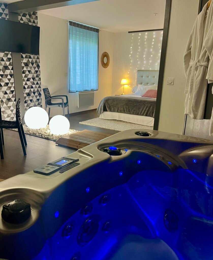 Suite avec spa privatif illuminé de bleu et chambre décorée, une idée de séjour à offrir en carte cadeau Découverte.