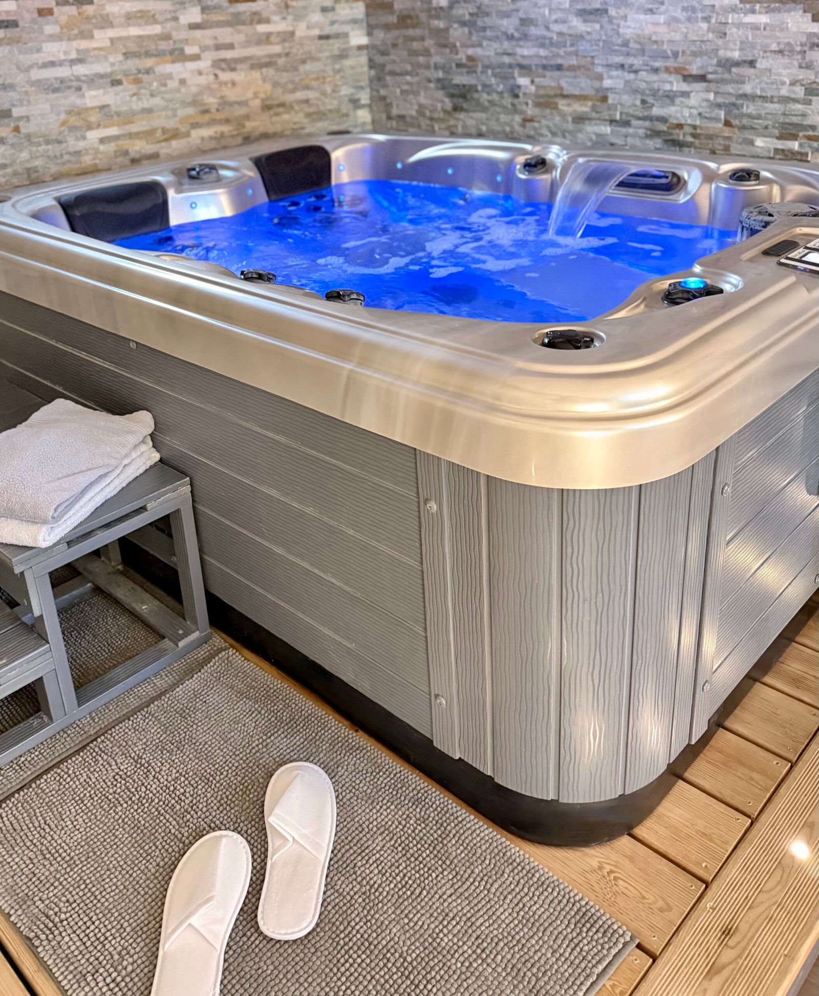 Lumière tamisée et ambiance cocooning autour du spa de la Suite Minérale pour une soirée bien-être.