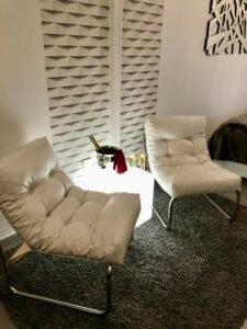Petit coin lecture avec fauteuil confortable et lumière tamisée pour une soirée relaxante dans la suite.
