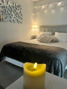Lit douillet avec jeté de lit en laine et coussins moelleux pour un séjour cocooning proche du Mont Saint-Michel.