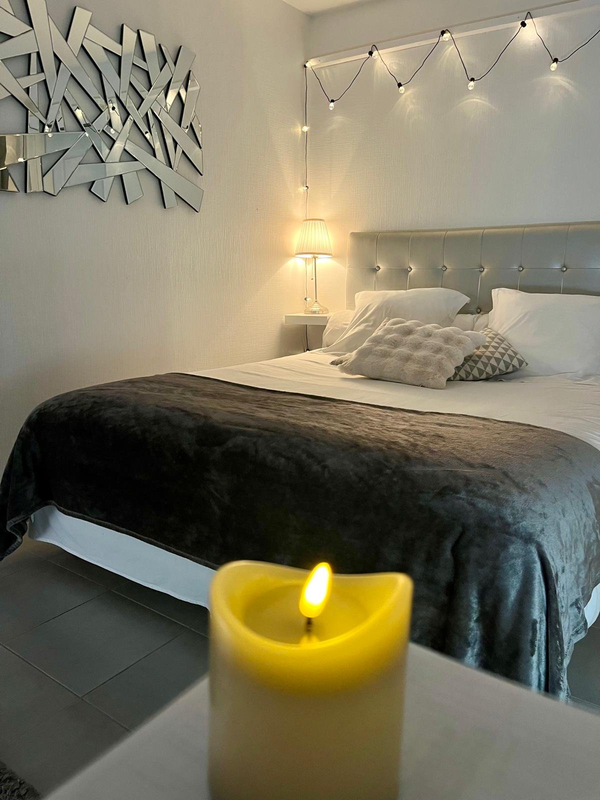 Lit douillet avec jeté de lit en laine et coussins moelleux pour un séjour cocooning proche du Mont Saint-Michel.
