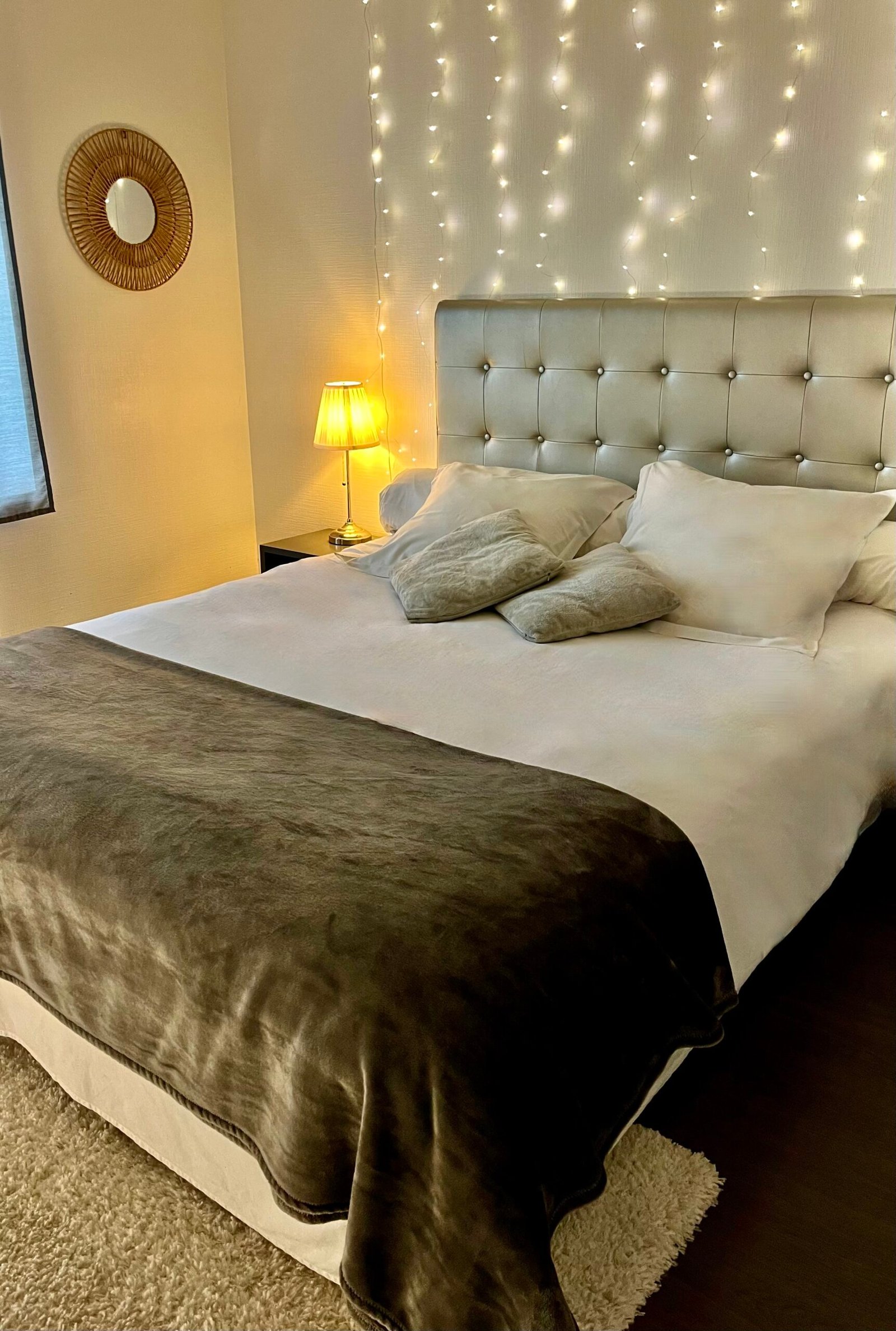 Lit double spacieux avec tête de lit aux tons minéraux et éclairage tamisé pour une nuit paisible.