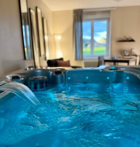 Espace bien-être privatif de la Suite Minérale avec baignoire balnéo pour une détente totale.